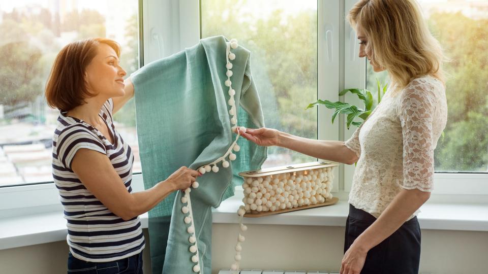 A woman showing another woman curtain designs