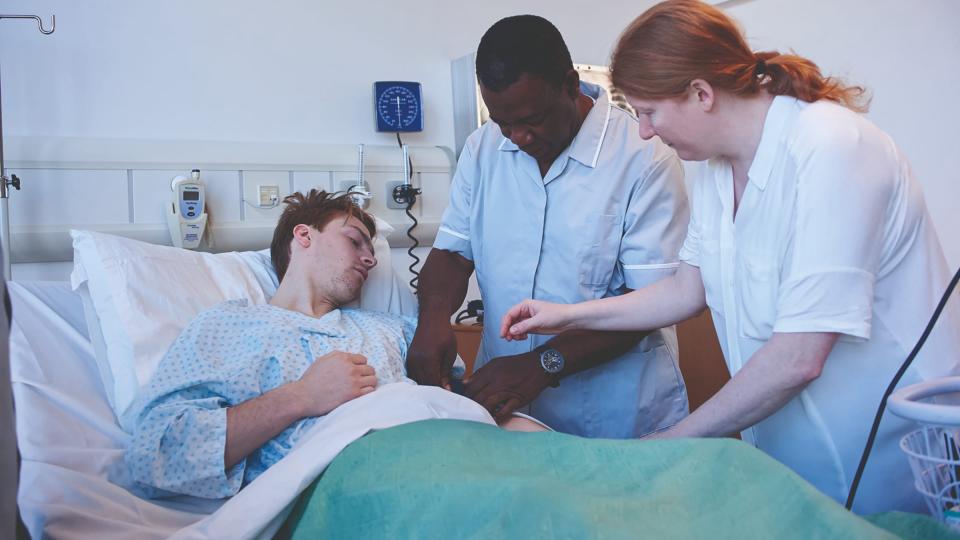 A male and female nurse attending to a male patient