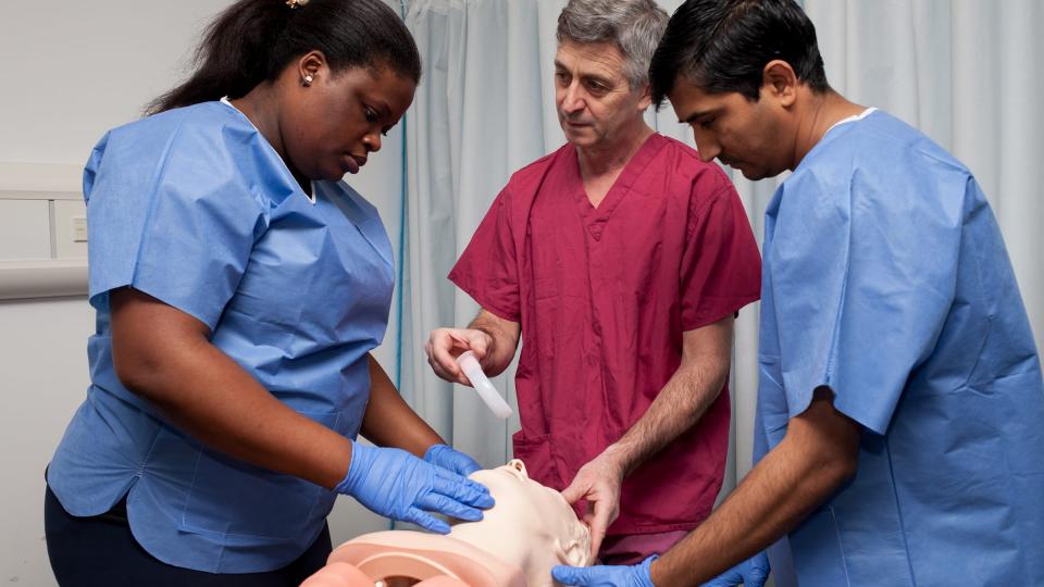 Two male nurses and a female nurse in a hospital ward setting