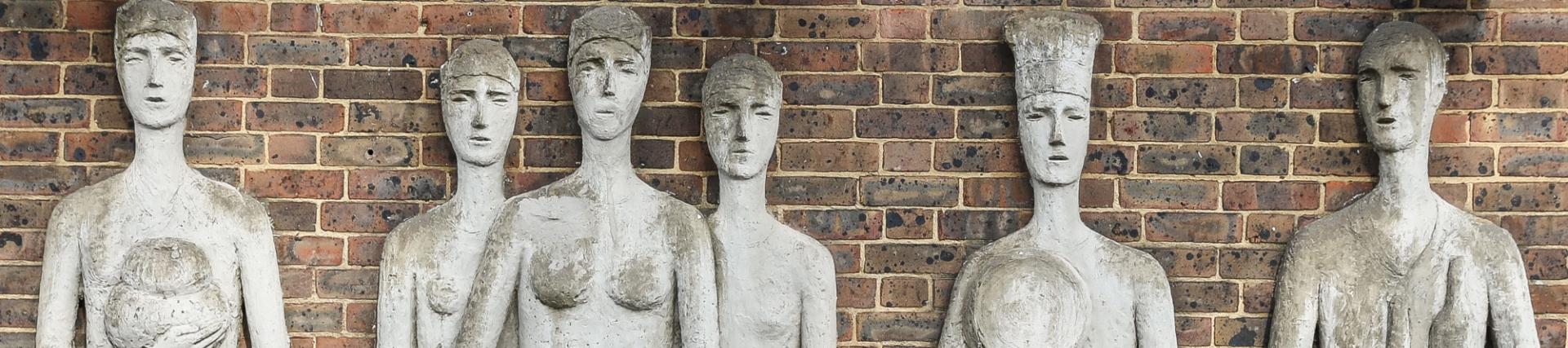 Stone sculptures against brick wall at St. Mary's Campus in Ealing.