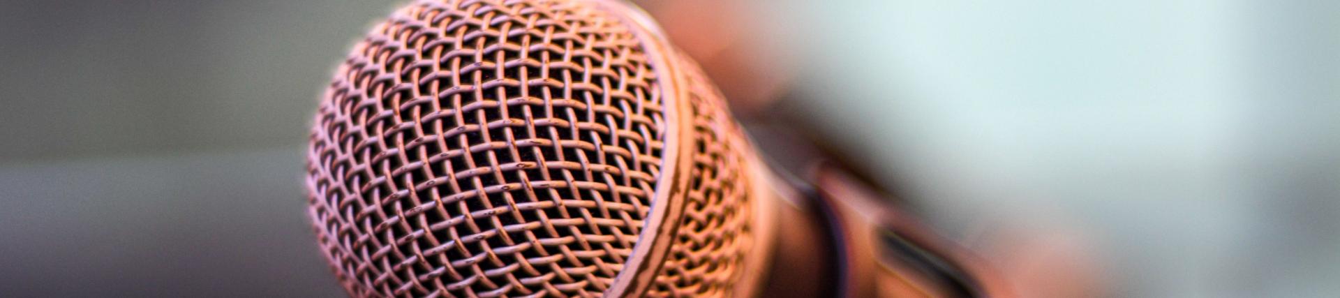 Close up of a microphone in front of a blurred background
