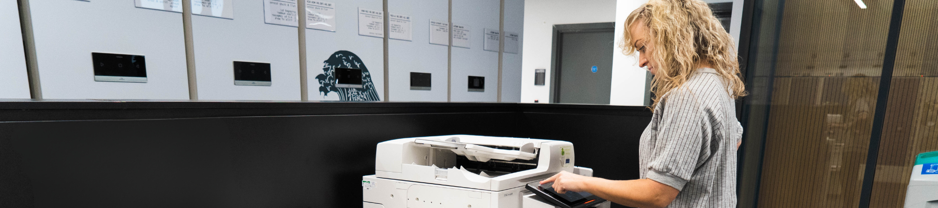 A female student using the printer and photocopier in the library.