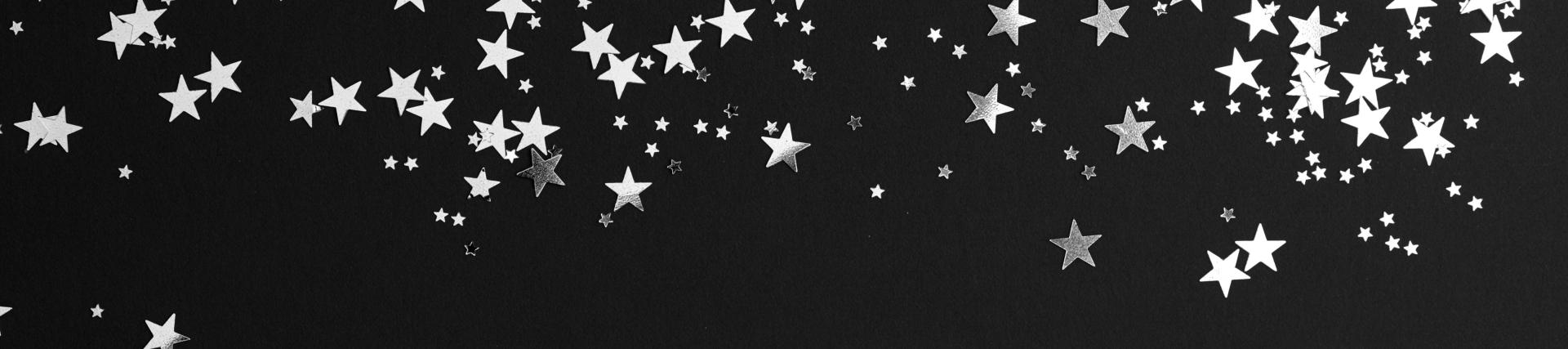 Silver star confetti on a black background.