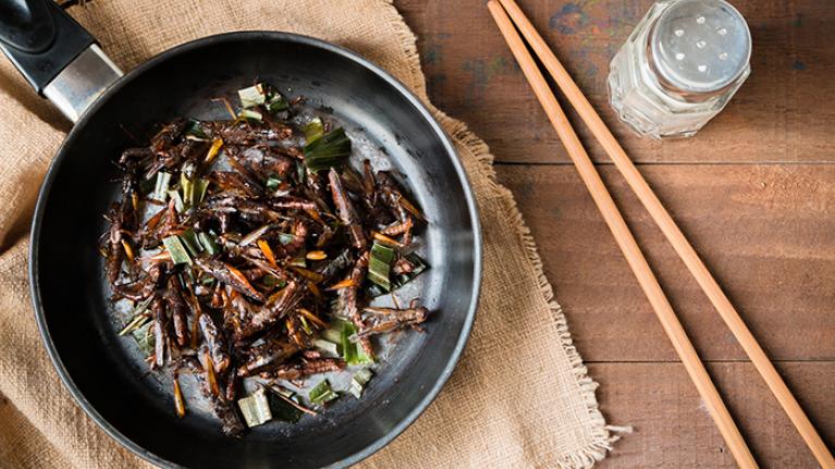 A frying pan full of cooked insects.