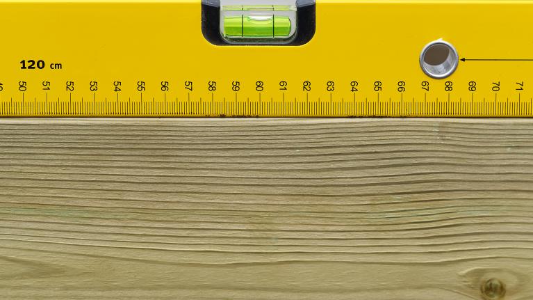 A spirit level on a plank of wood.