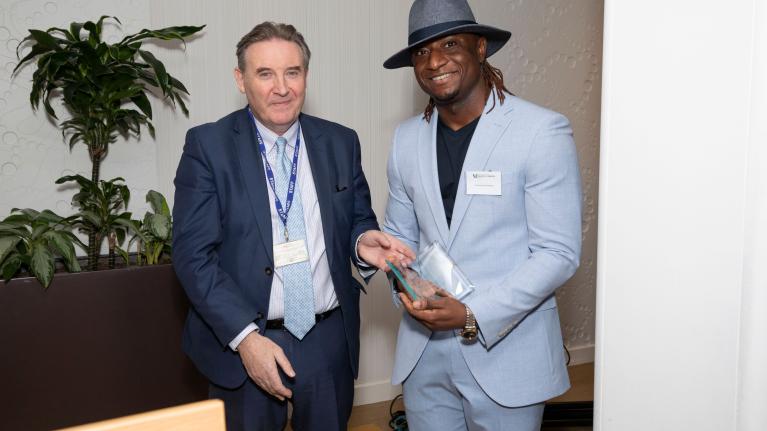 Emmanuel Ebokosia is standing with Professor Peter John CBE, accepting an award at the UWL Alumni Awards 2023.