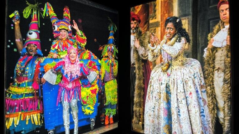 Photos of actors in colourful dress on display inside the Globe theatre