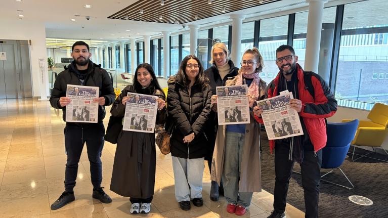 LSFMD Journalism students smiling and holding copies of The Guardian in their archive