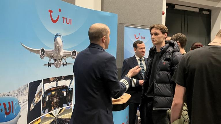 A prospective student talks with a representative from TUI at the LCGHT Future Pilots event